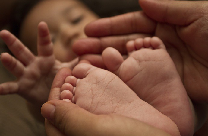 Baby feet closeup with mom holding him