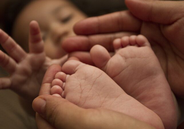 Baby feet closeup with mom holding him